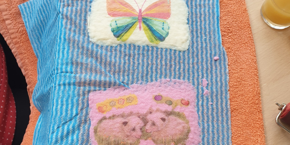 Schmetterlings- und Osterlammmotiv auf geschöpftem Papier zum Trocknen ausgelegt