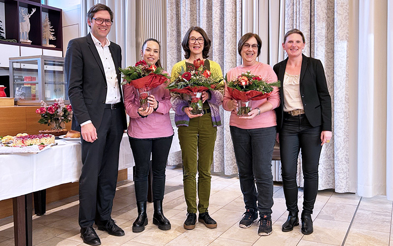Mitarbeitende der Begegnungsstätte Stammheim stehen bei einer Abschiedsfeier mit Blumensträußen im Luise-Schleppe-Haus zusammen.